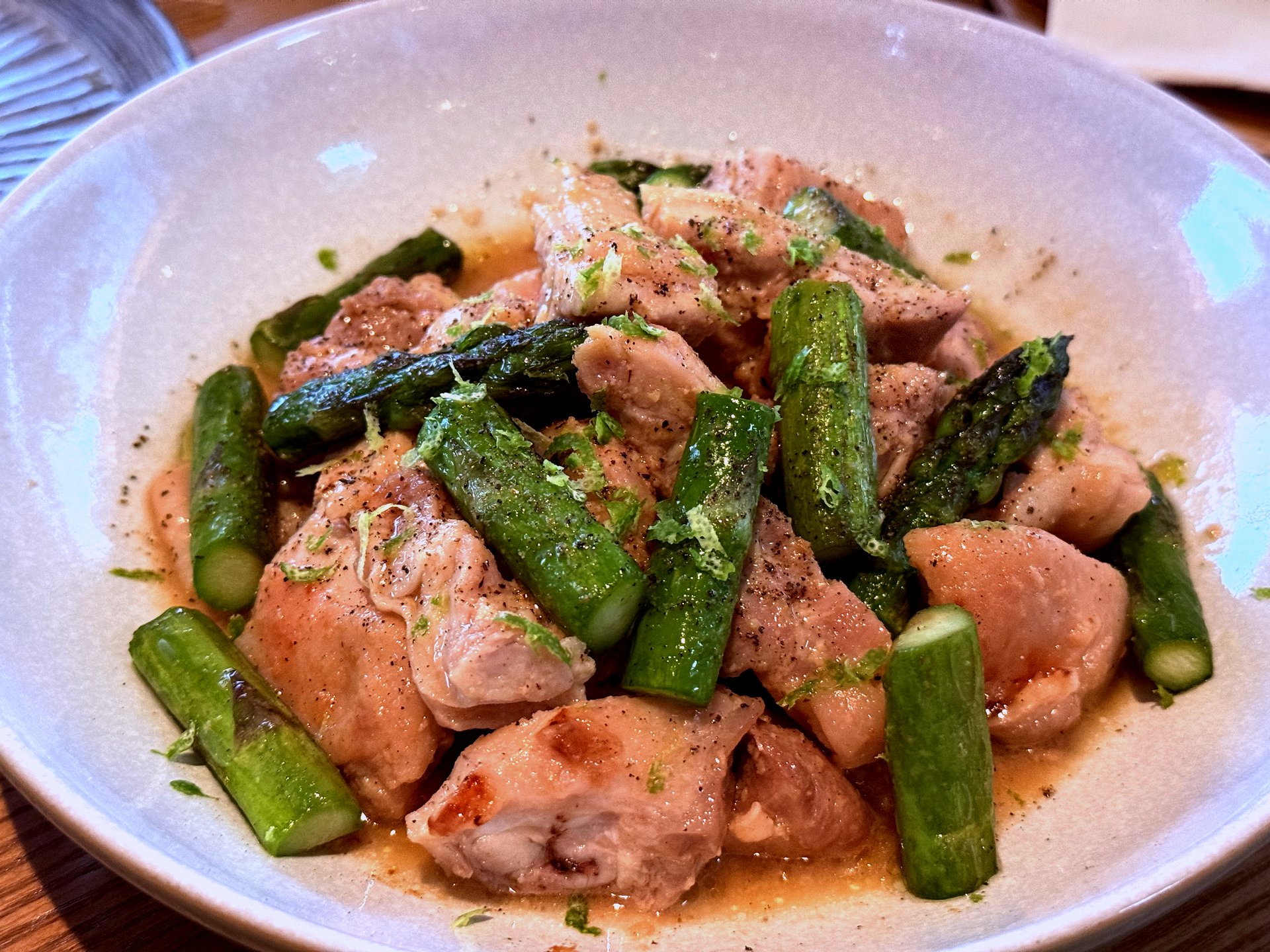 Doenjang-marinated chicken thigh pieces with bright green asparagus spears