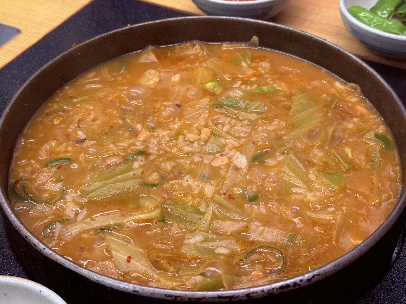 Doenjang sool bap - bubbling bean-paste rice stew with cabbage and rice in cast-iron pan