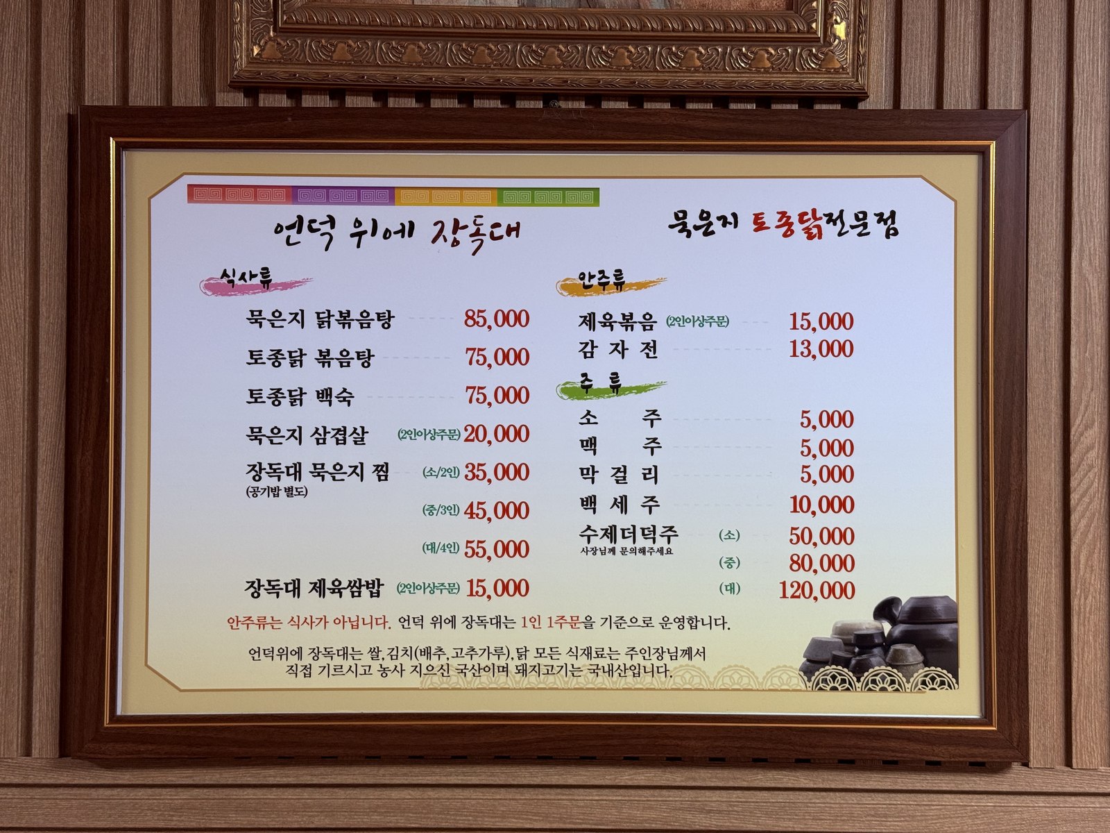 Framed Korean-only menu at Eondeokwie Jangdokdae - meal categories include kimchi-jjim sizes, baeksuk, native-chicken dishes, jeyuk pork, prices in won