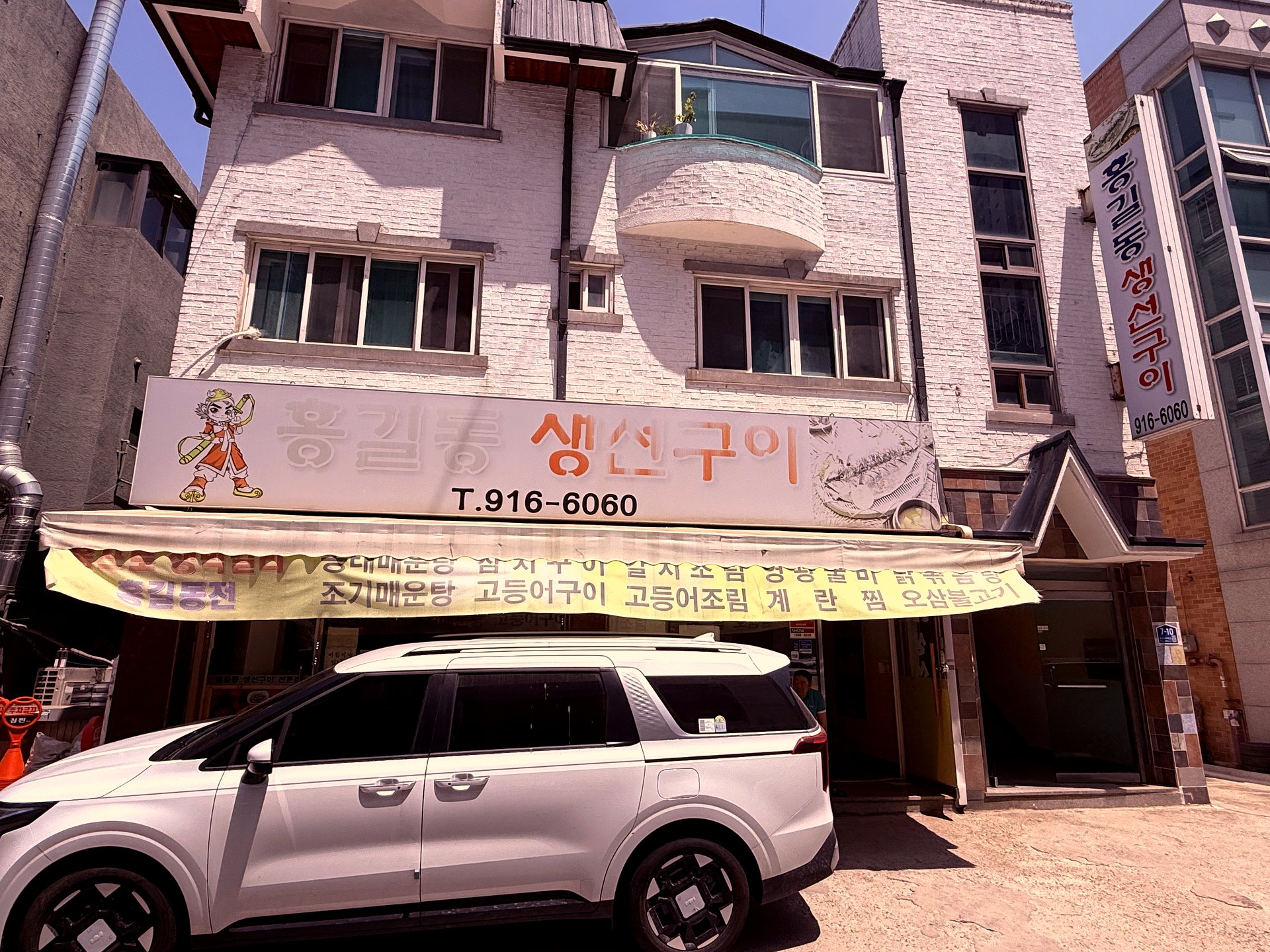 Exterior - small two-story building with Hong Gildong cartoon mascot signage