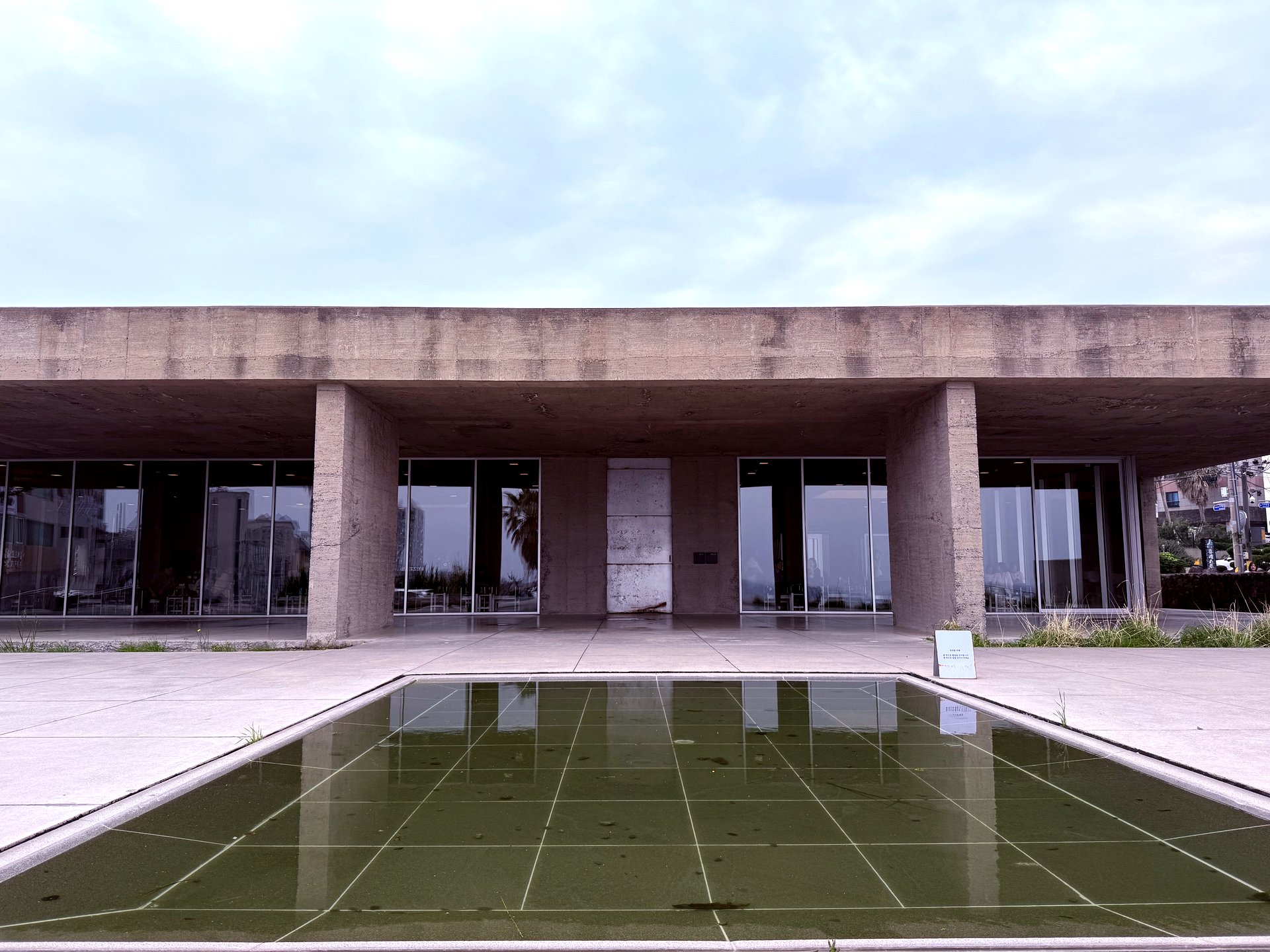 Brutalist concrete exterior with reflecting pool