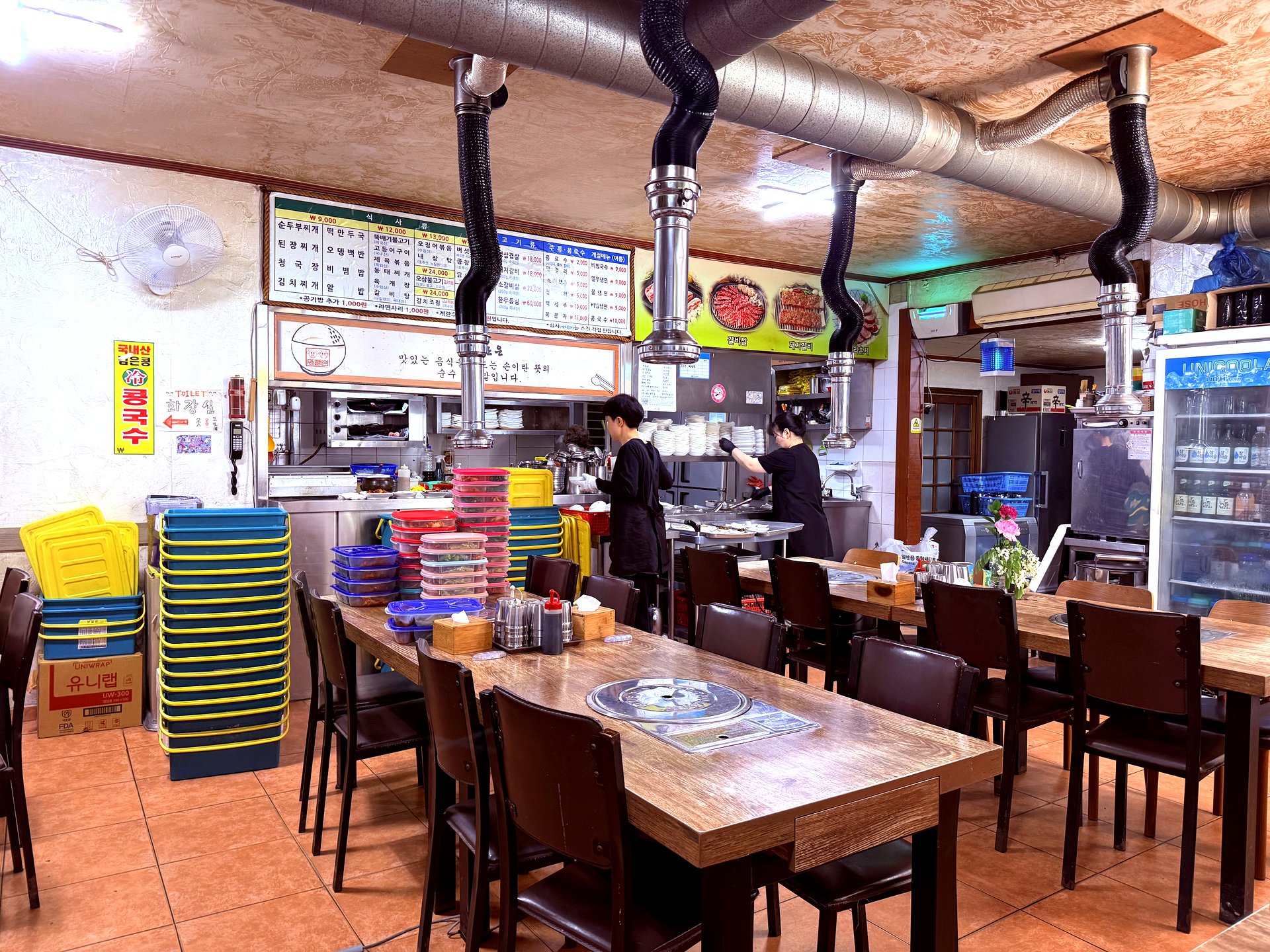 Inside the gisa-sikdang dining room with steel ducts and stacked delivery boxes