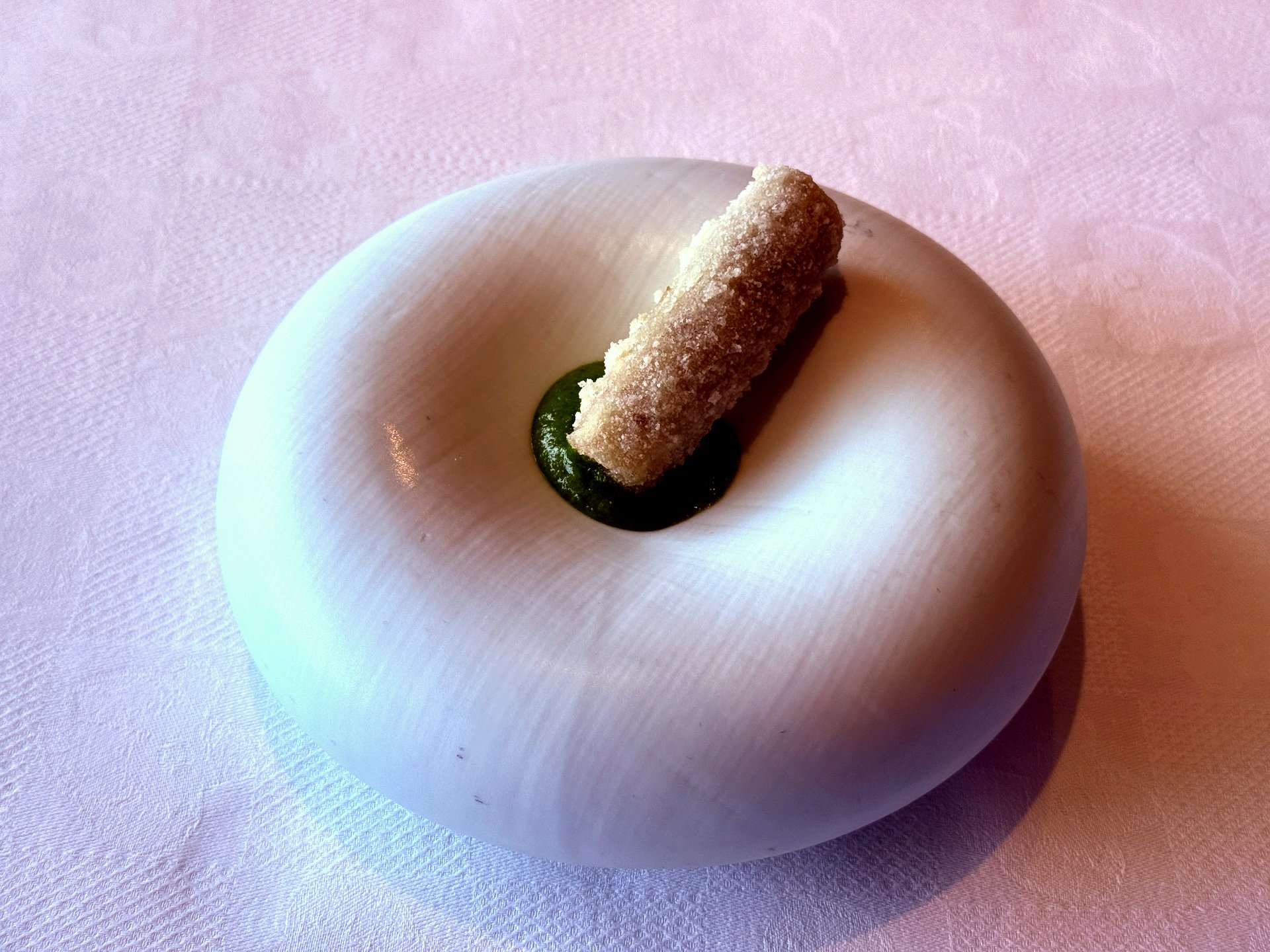 Crispy burdock root with shepherd's purse on a smooth white stone-shaped plate