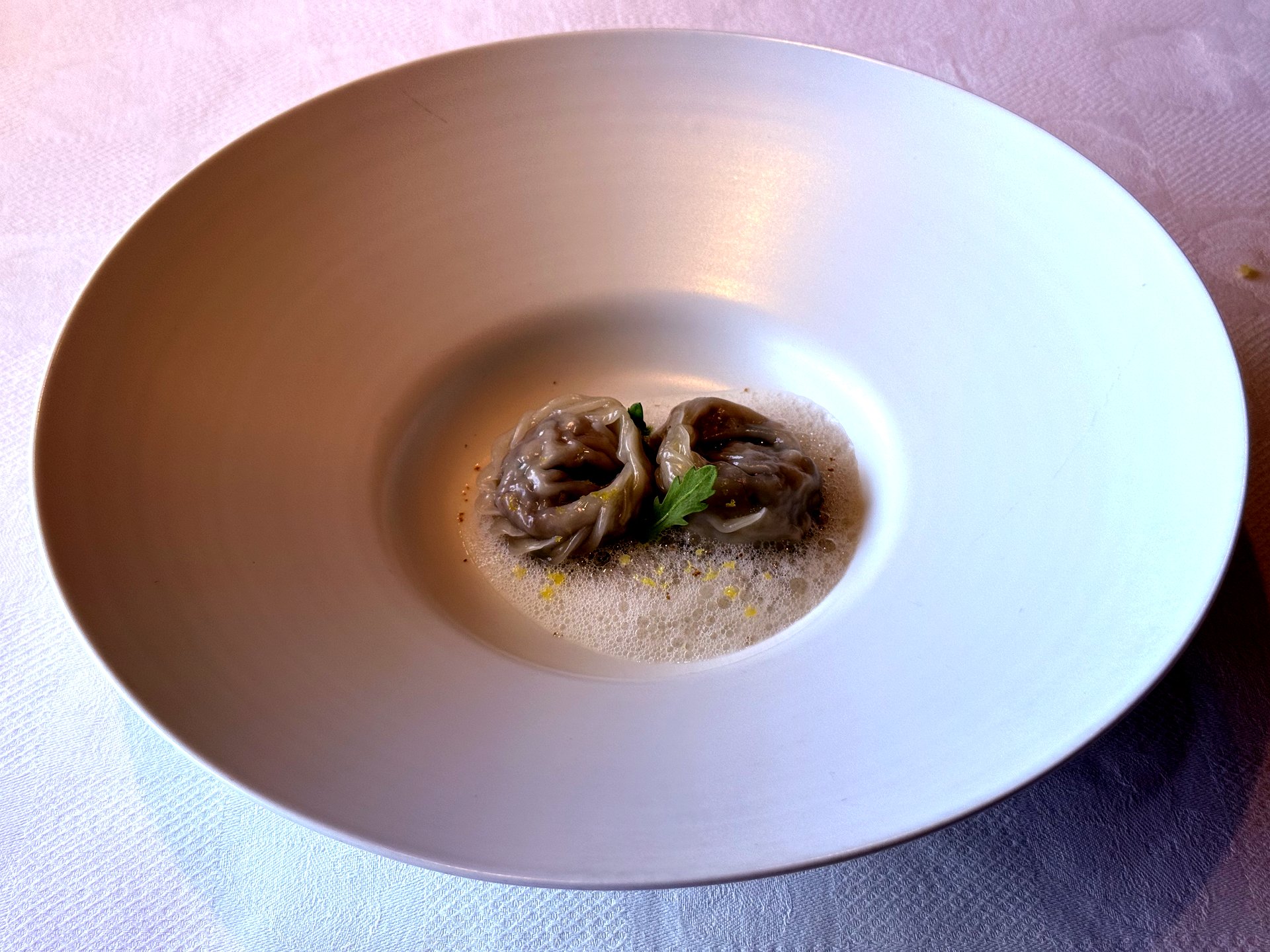 Two hanwoo brisket and wild-chive dumplings in clear beef broth with foam