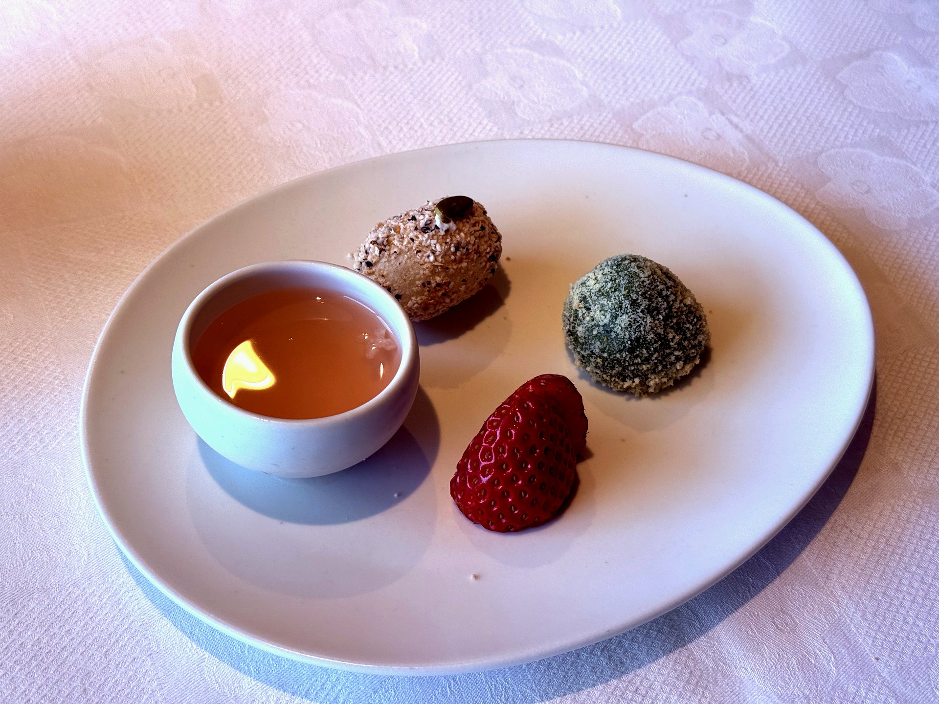 Korean traditional tea with mugwort rice cake, sesame ball, and fresh strawberry