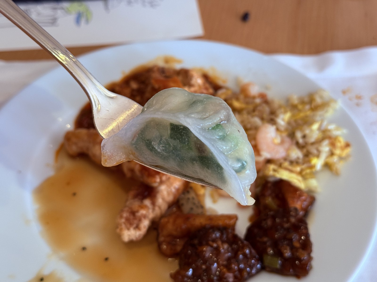 Buchaegyo dim sum on fork close-up - translucent skin showing green chive filling inside