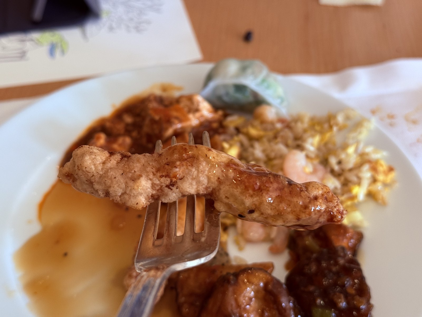 Sweet and sour pork tangsuyuk on fork - golden battered pork with glossy sauce