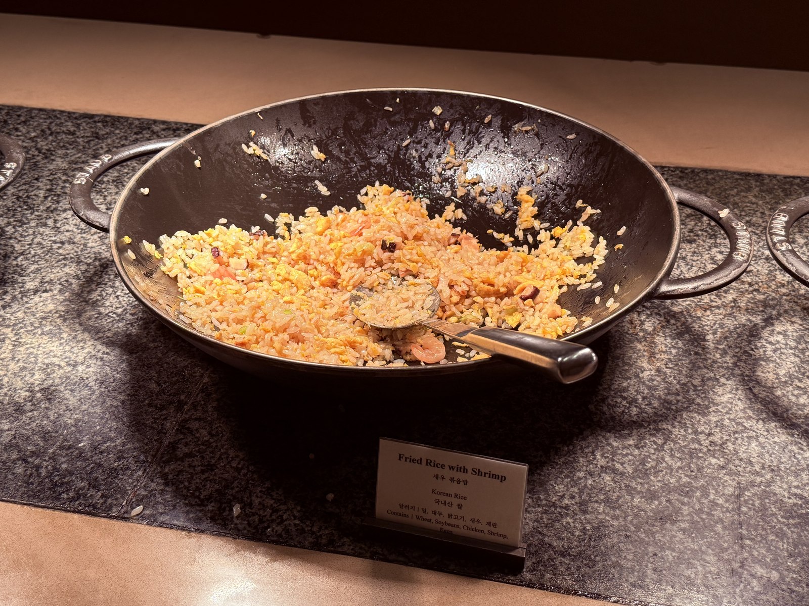 Garlic fried rice in steel wok - yellow grains flecked with toasted garlic and egg