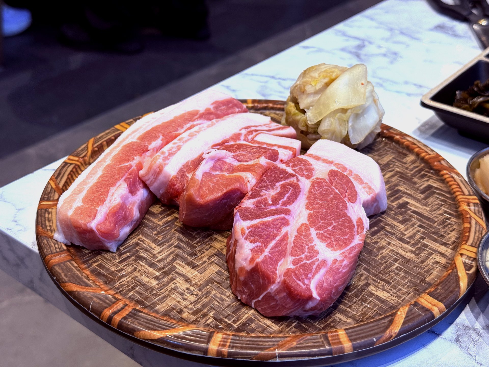 Raw cuts on a woven basket - 720hr aged samgyeopsal and ogyeopsal