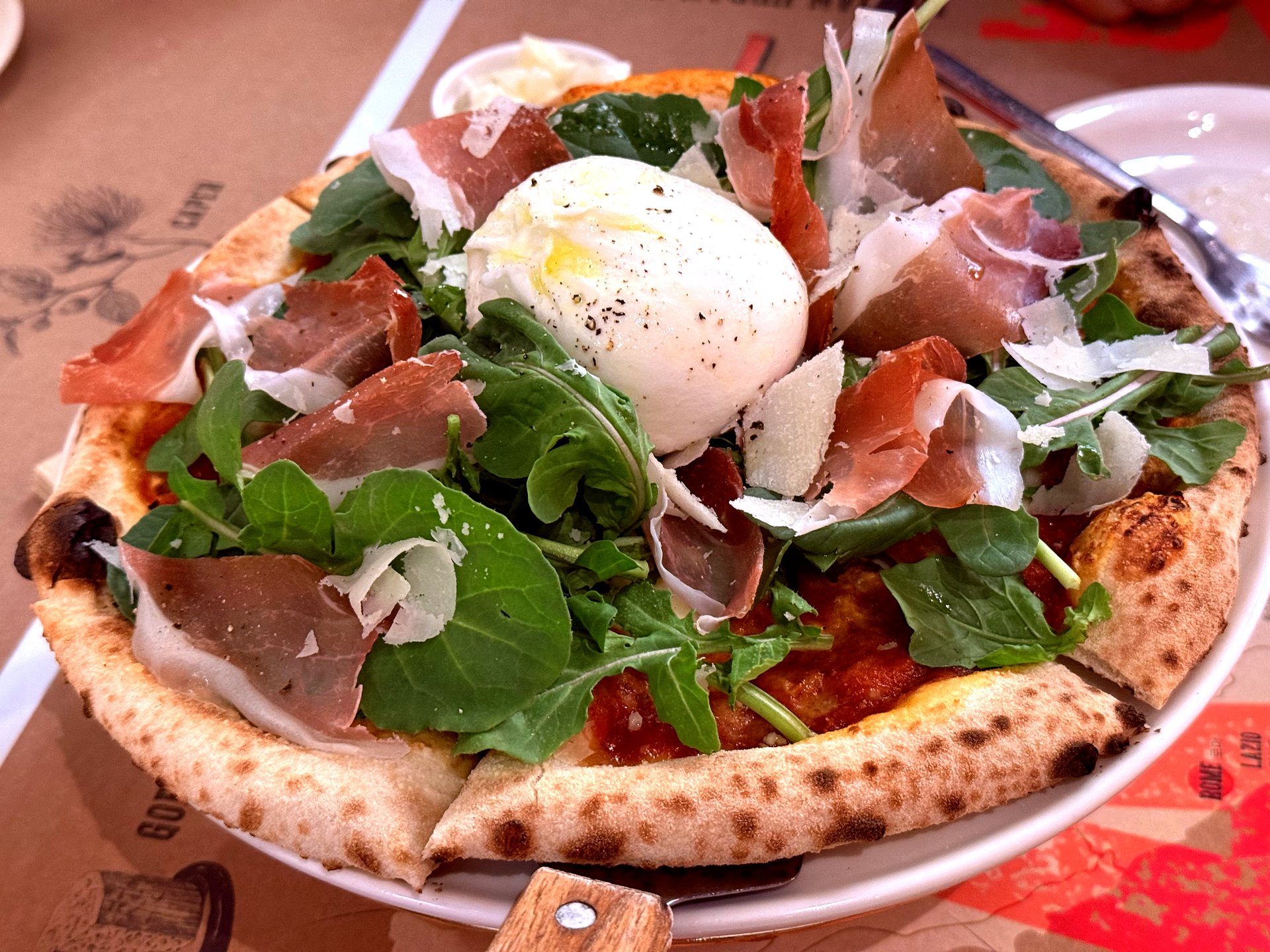 Arugula-prosciutto pizza with parmesan shavings and added burrata