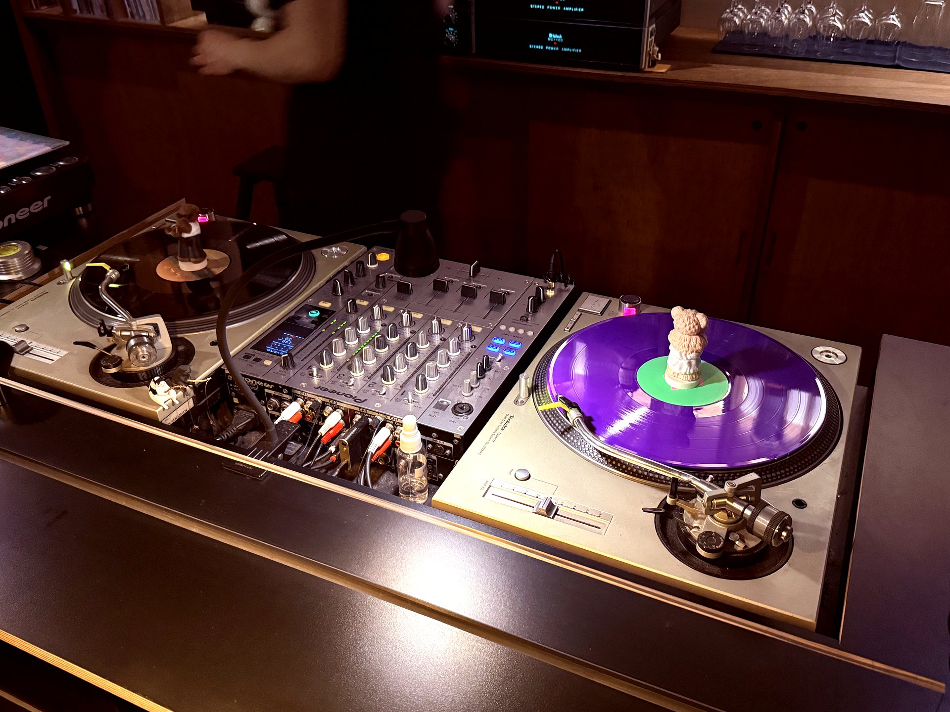 Pioneer turntable with a purple-vinyl LP spinning, mixer alongside