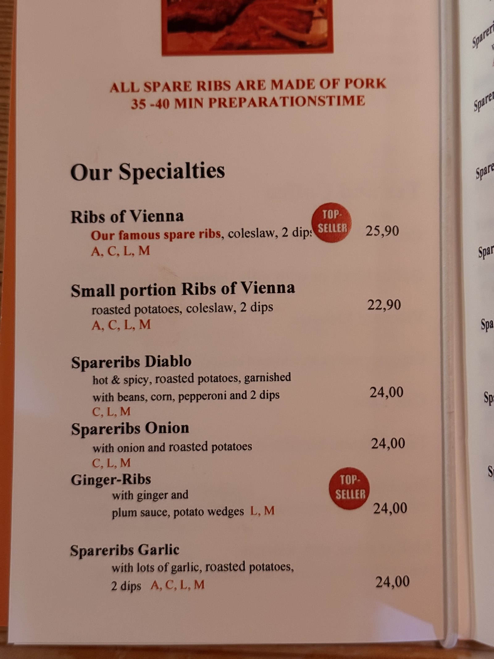 Ribs of Vienna 'Our Specialties' menu page - black heading text 'ALL SPARE RIBS ARE MADE OF PORK / 35-40 MIN PREPARATION TIME' with six rib options listed with prices ranging from 22.90 to 25.90 euros, two TOP SELLER red badges next to Ribs of Vienna and Ginger-Ribs