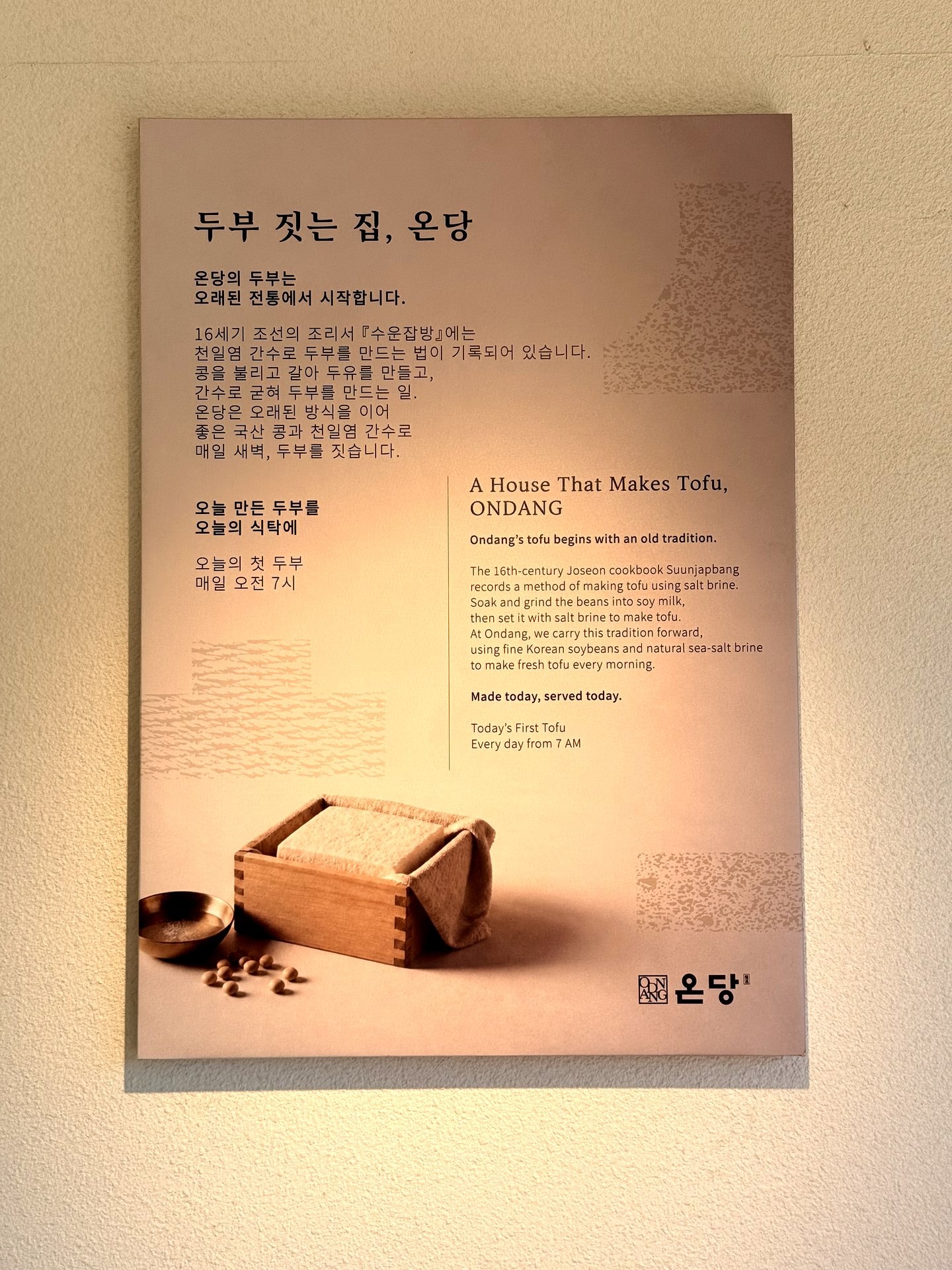 A wall panel at Ondang titled 두부 짓는 집, 온당 (A House That Makes Tofu, Ondang) explaining that its tofu follows a 16th-century Joseon recipe using Korean soybeans and sea-salt brine, made fresh every morning, with a photo of tofu setting in a wooden mold