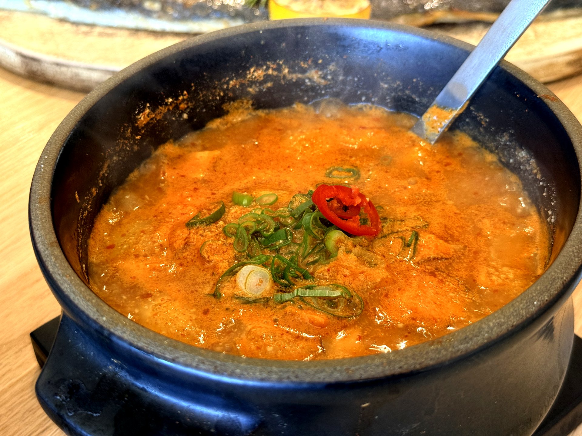 Ondang 비지찌개 (soybean-pulp stew) - a bubbling earthenware pot of thick, nutty reddish soybean-pulp stew topped with sliced scallion and a ring of red chili