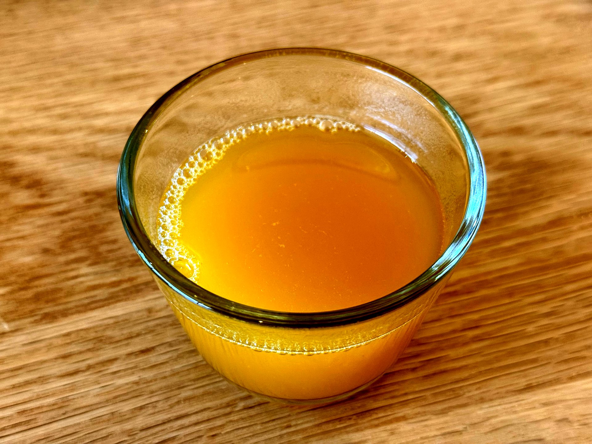 Ondang 호박식혜 (sweet pumpkin rice drink) - a glass tumbler of chilled golden-yellow pumpkin sikhye, a traditional sweet Korean rice-malt beverage, on a wooden table