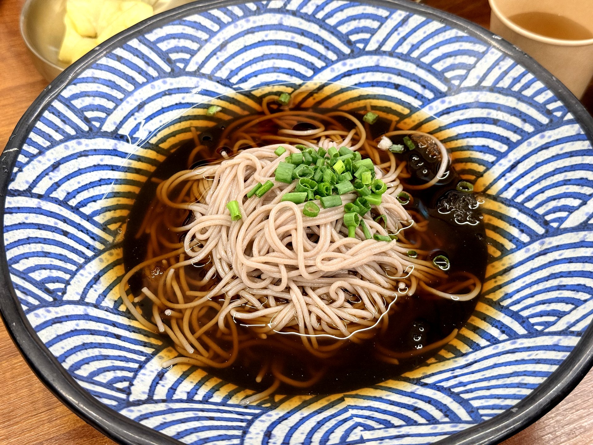 Memilbat-e Gasiri cold soba - buckwheat noodles in a chilled dark soy-dashi broth topped with chopped scallion, in a blue-and-white wave-patterned bowl